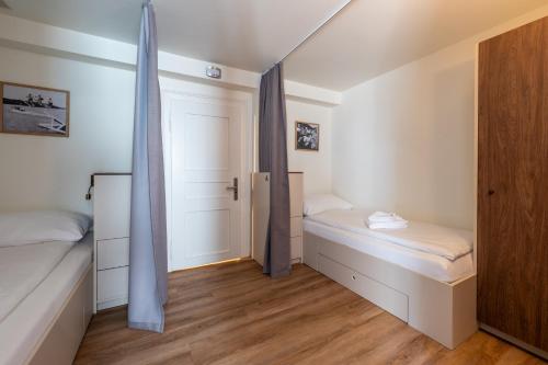 a small room with two beds and a closet at Hotel Ochsen - Self Check-in in Uster