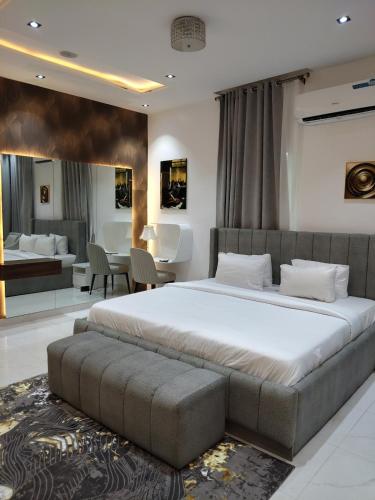 a bedroom with a large bed and a living room at 5 bedroom apartment Magodo GRA in Sagisa