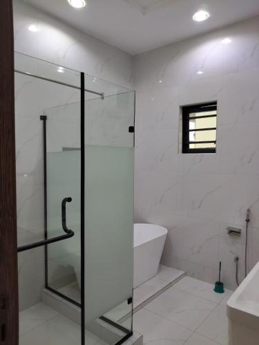 a bathroom with a glass shower and a bath tub at 5 bedroom apartment Magodo GRA in Sagisa