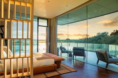 a bedroom with a bed and a large glass wall at Pristine Mara Bay Lodge in Masai Mara