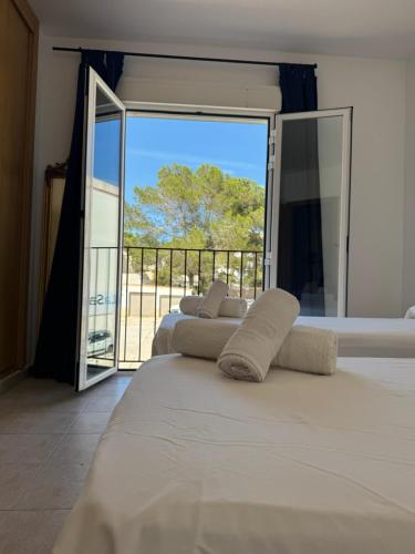 a bedroom with two beds and a balcony with a view at Espalmador E10, RT259PL in Es Pujols
