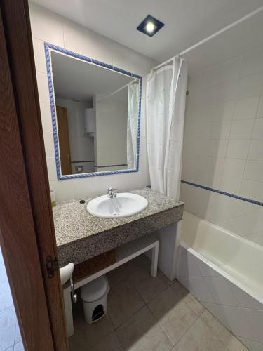 a bathroom with a sink and a mirror and a tub at Espalmador E10, RT259PL in Es Pujols
