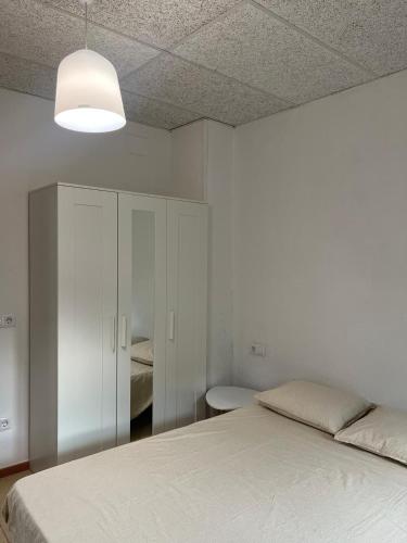 a white bedroom with a bed and a white cabinet at La Sabonnera in Sant Llorenç de la Muga