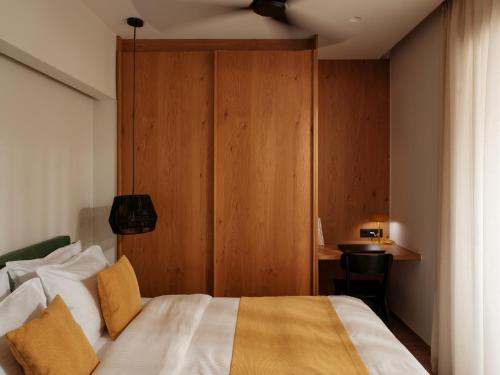 a bedroom with a bed and a wooden wall at Eudaimonia - Luxury Apartment in Agrinio in Agrinio