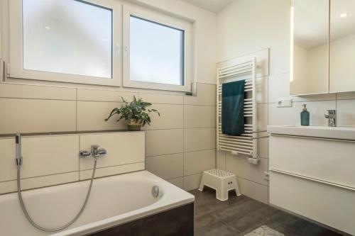 a bathroom with a tub and a sink at Ferienwohnung Marla in Eriskirch