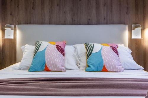 a bedroom with a bed with pillows on it at NURAS - DomoDé in Alghero
