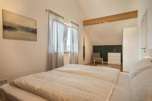 a bedroom with a large bed and a window at Ferienwohnung Marla in Eriskirch