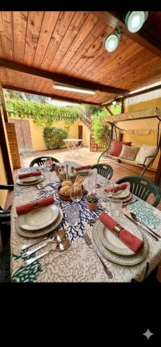 a table with plates and utensils on top at Le Case dei Ginepri in Marina di Sorso