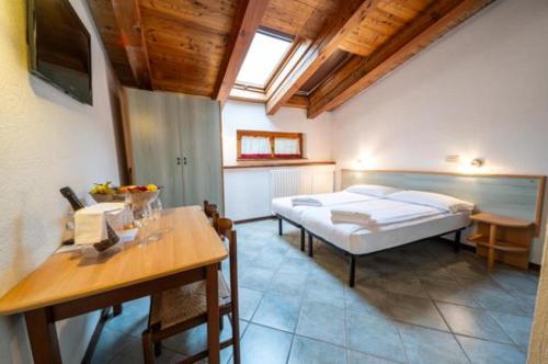 a bedroom with a bed and a desk and a table at Residence Nube D'Argento in Sestriere
