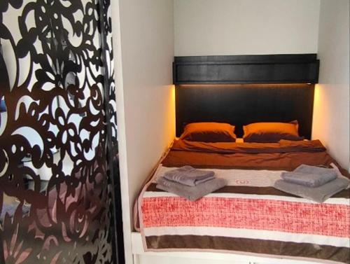 a bedroom with a bed with orange pillows at Kipsala Cozy Apartment in Riga