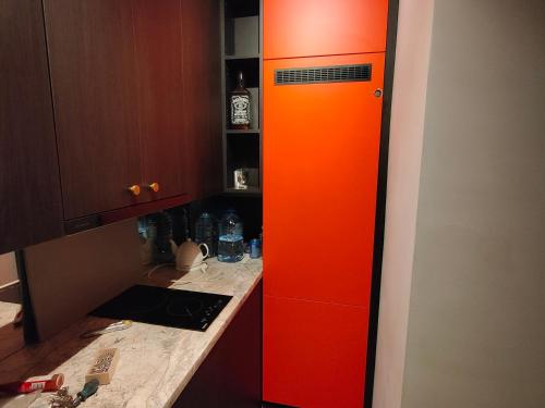 an orange cabinet in the corner of a kitchen at Kipsala Cozy Apartment in Riga