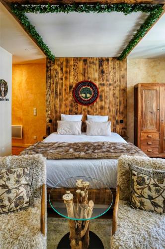 a bedroom with a bed and a glass table at Le Jardin de Freya - Balnéo - Centre historique in Auch