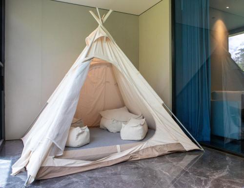 a teepee tent with pillows in a room at Pristine Mara Bay Lodge in Masai Mara