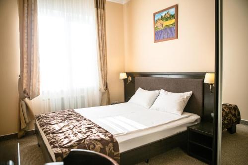 a hotel room with a bed with a window at Churchill-Inn in Vinnytsya