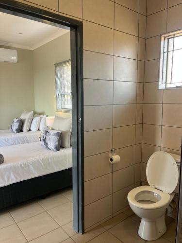 a bathroom with a bed and a toilet in a room at Wonderwerk cave adventures in Kuruman