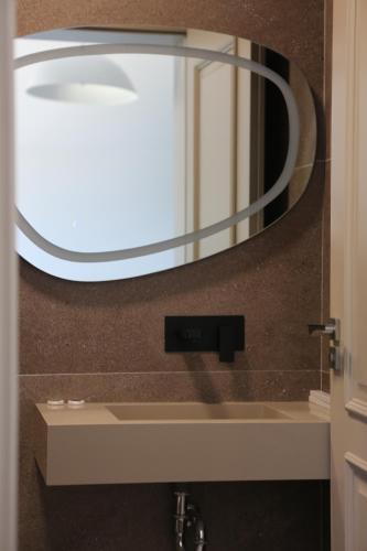 a mirror on a wall above a bathroom sink at Lala Resort in Kolgecaj