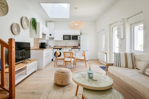 a living room with a couch and a table at La Cabane chic des Embruns in Cabourg