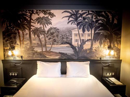 a bedroom with a painting above a bed with two pillows at Hôtel Mercure Rochefort La Corderie Royale in Rochefort