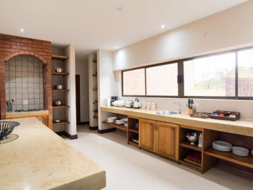 a kitchen with a sink and a large window at Sweet Zebula in Mabula