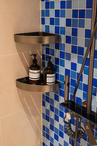 a shelf with two bottles on a blue tiled wall at SOLANA VILLA Cửa Lò - Biệt thự nghỉ dưỡng cao cấp tiêu chuẩn 5 sao in Cửa Lô