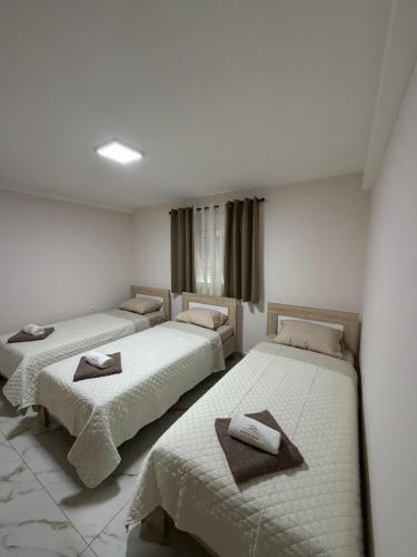a room with three beds with towels on them at Apartmani Kastratovic in Golubovci