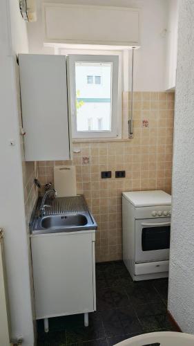 a small kitchen with a sink and a window at vacanza in appartamento sul mare in Fano