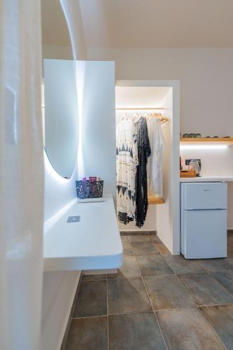 a walk in closet with a white bench in a room at Ligaries in Kini