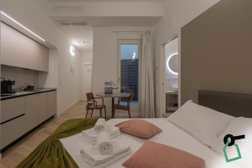 a bedroom with a bed and a kitchen with a table at Hotiday Trieste Teatro in Trieste