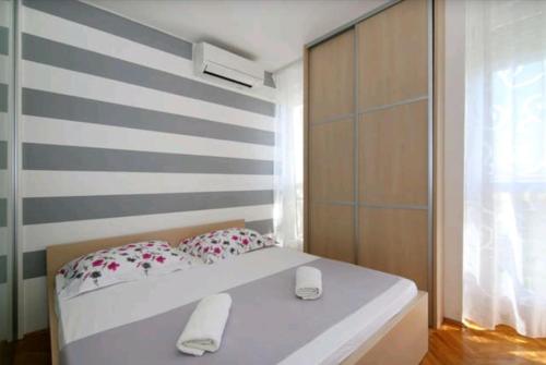 a bedroom with a white bed and a striped wall at Apartment Split Sun in Split