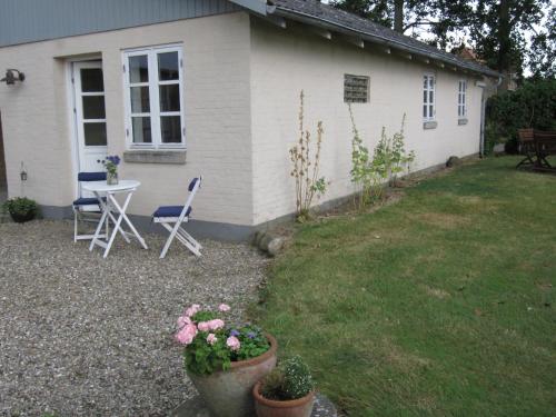 a house with a table and chairs in a yard at Sønderborg Kær Vestermark in Sønderborg