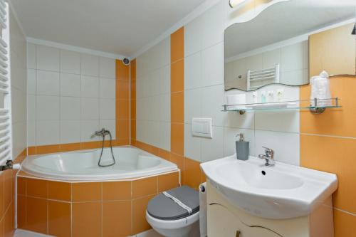 a bathroom with a sink and a toilet and a tub at Penzion Miromar in Podivín