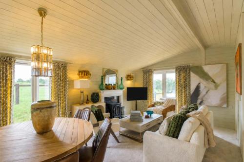 a living room with a table and a couch and a fireplace at The Paddock Lodge in Withcote