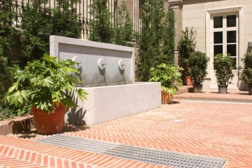 a fountain in front of a building with plants at Villa Oniria in Granada