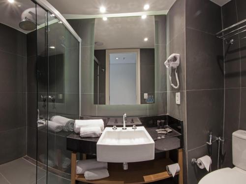a bathroom with a sink and a toilet and a mirror at ibis Styles Parauapebas in Parauapebas
