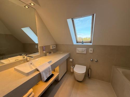 a bathroom with a sink and a toilet and a mirror at Schlosshotel Grünwald in Grünwald