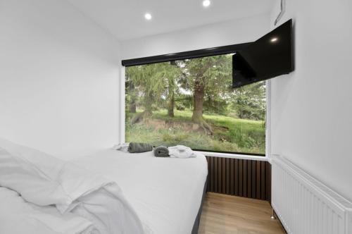 a bedroom with a large window with a white bed at Umry-Calm Farm Stays in Feeny