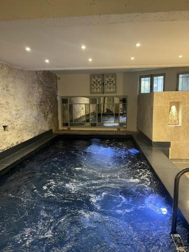 an indoor pool with blue water in a building at Les Suites de L’Opéra in Vichy