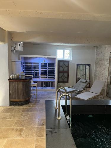 a room with a tub and a table and chairs at Les Suites de L’Opéra in Vichy