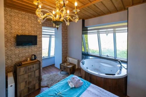 a large bathroom with a tub and a tv at Poison Garden Suite & SPA in Gözalan