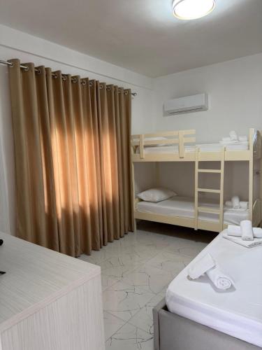 a room with two bunk beds and a curtain at Aurea Rooms in Vlorë