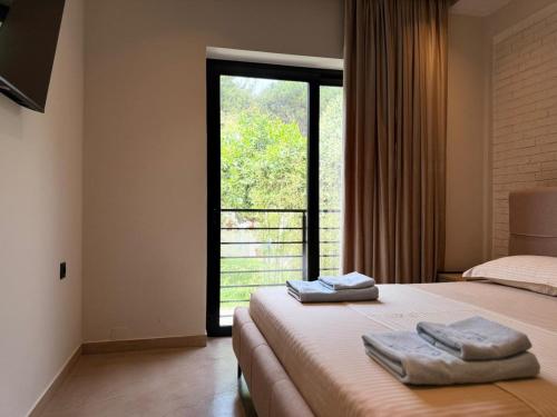 a bedroom with a bed with two towels on it at Ritson Hotel in Vlorë