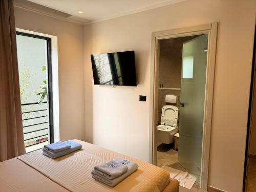 a bedroom with a bed and a bathroom with a toilet at Ritson Hotel in Vlorë