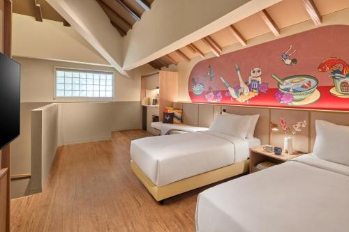 a bedroom with two beds and a painting on the wall at lyf Chinatown Singapore in Singapore
