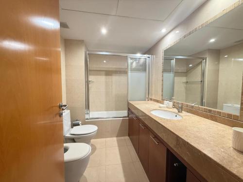 a bathroom with two toilets and a sink and a mirror at Apartment in Castelldefels! in Castelldefels