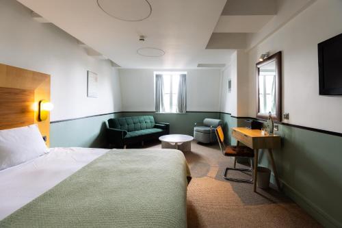 pokój hotelowy z łóżkiem, kanapą i stołem w obiekcie The Alan w Manchesterze