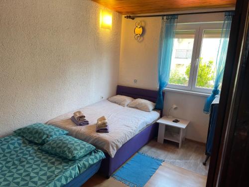 a small bedroom with a bed and a window at Dramalj apartman 4+1 in Dramalj