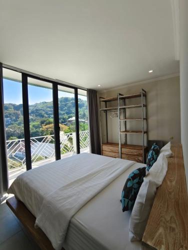 a bedroom with a large bed with a large window at Triple 888 Suites in Labuan Bajo