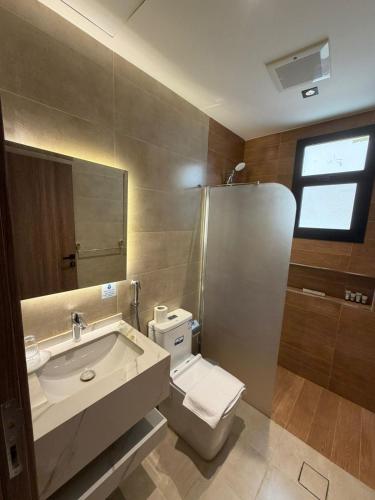 a bathroom with a toilet and a sink and a shower at ايا ان AYA Inn in Jeddah