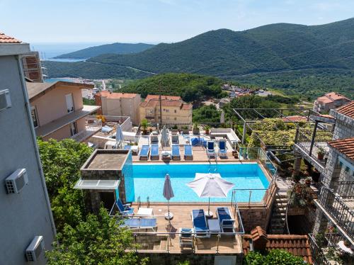 a pool with chairs and umbrellas on top of a building at Apartments Horizont in Budva