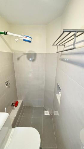 a white bathroom with a toilet and a shower at Wattle Residence Ngong in Ngong